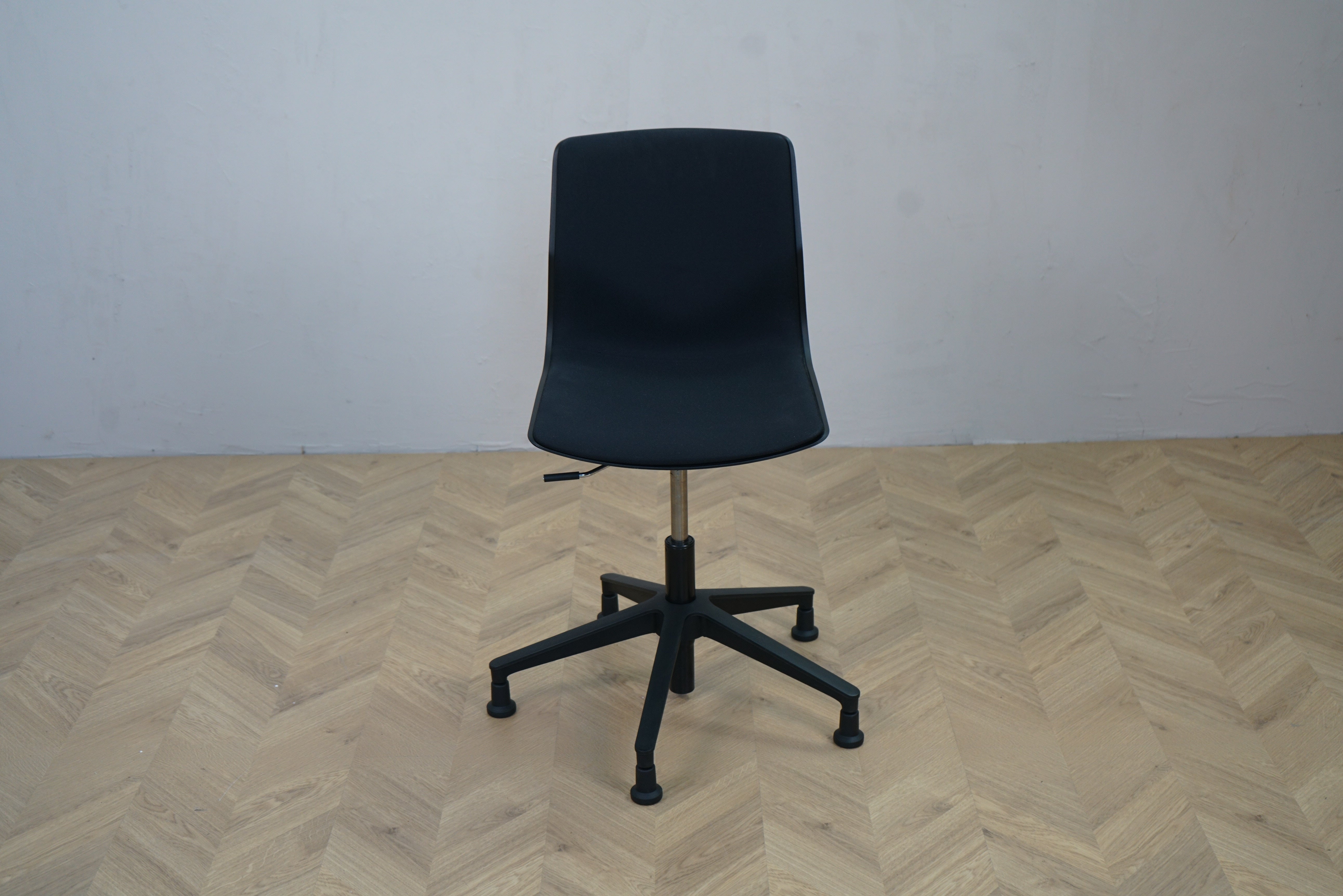 Four Design FourCast Wheeler2 mødestol i sort plast med polstret sæde set forfra, ergonomisk mødestol med hjul.